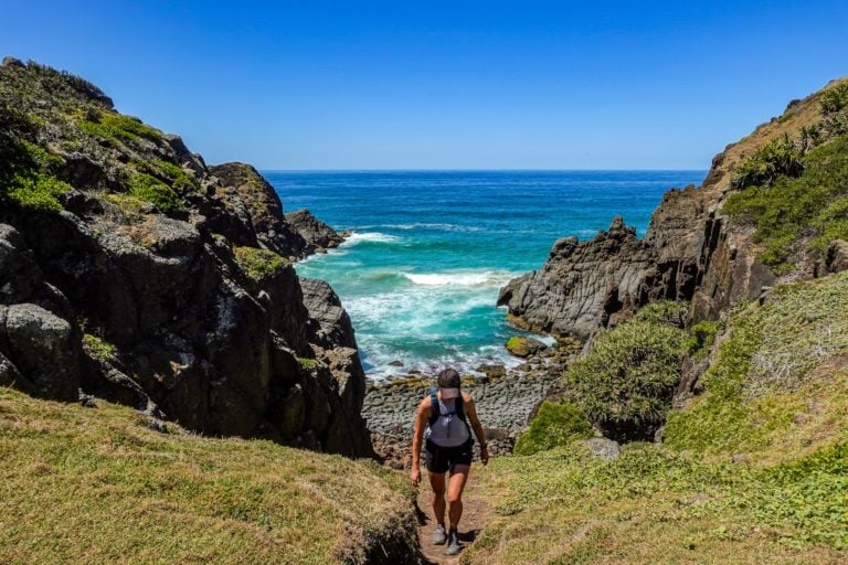 Beck walks away from a beach in a national park Hat Head National Park