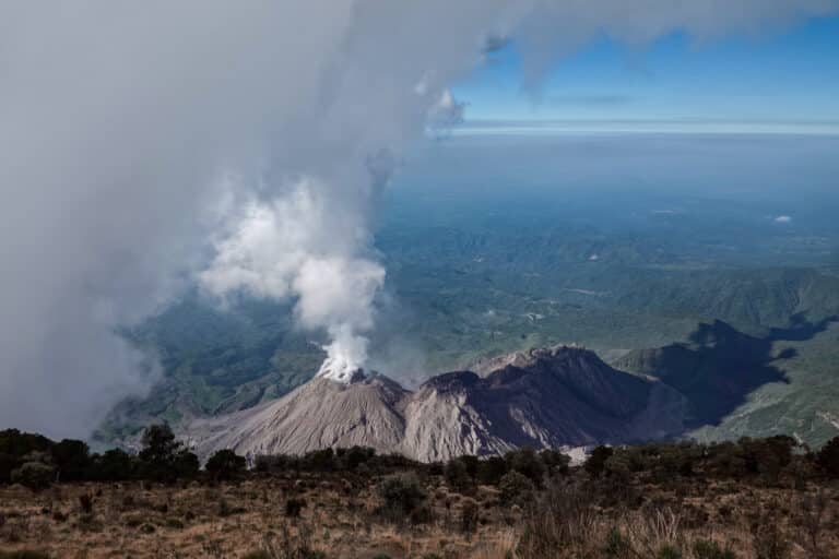 From Volcan Santa Maria, you can see views of Volcan Santiaguito emitting ash