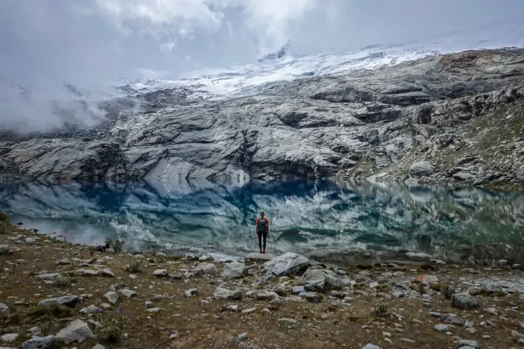 Beck stands by a lake during the Four Lagunas Trek, which is one of the best day hikes in Huaraz, Peru