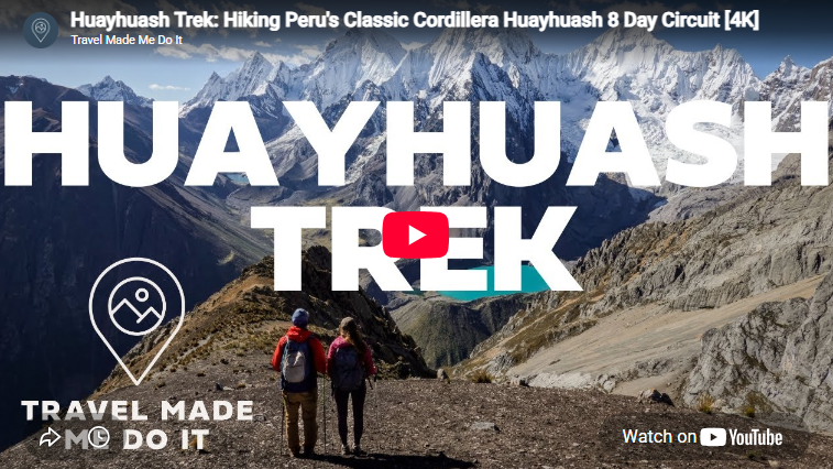 Dan and Beck look at a lake at the foot of snowy mountains during the Huayhuash Trek in Peru.