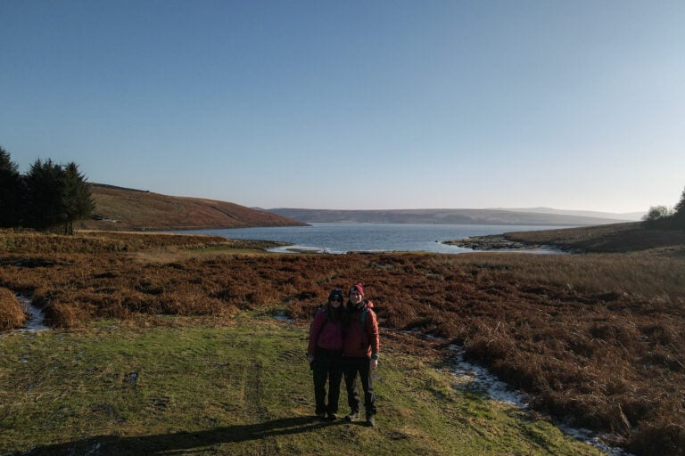 Dan and Beck stand in front of Grimwith Reservoir during a walk around it
