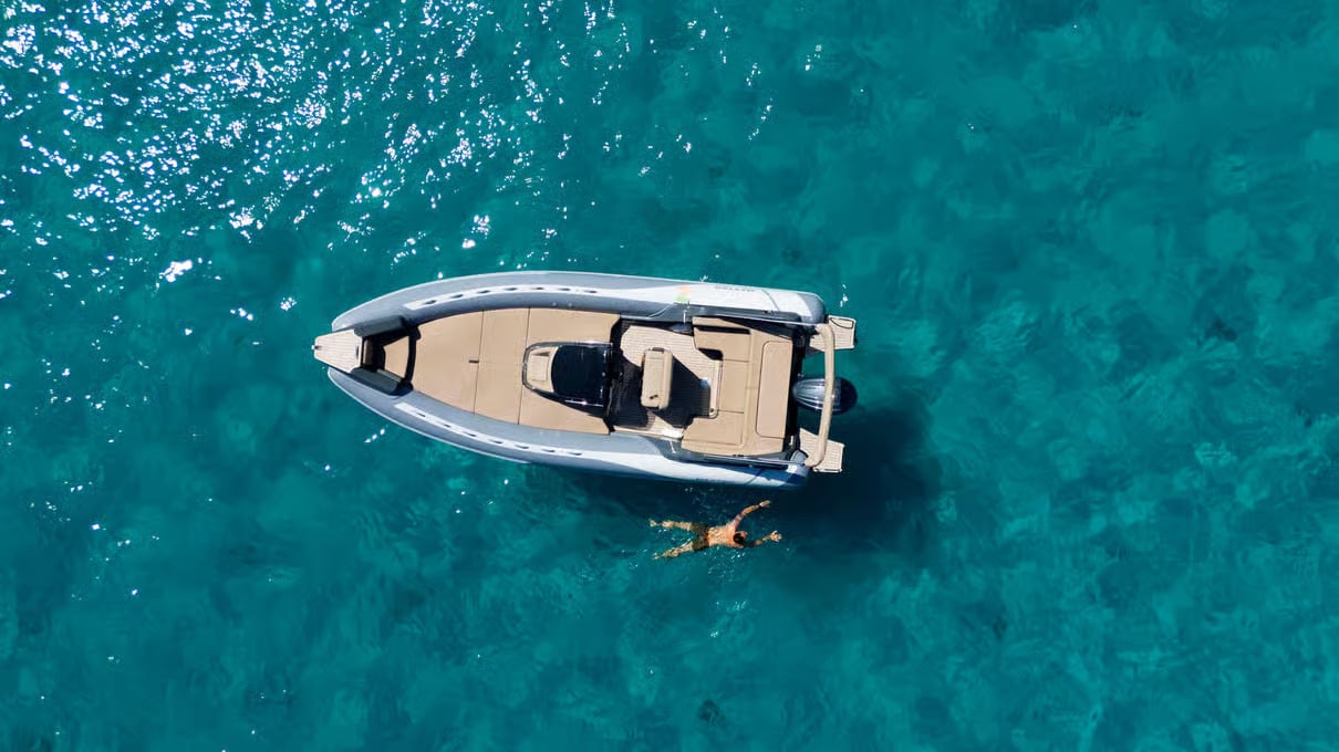 An aerial photo of a boat and someone swimming
