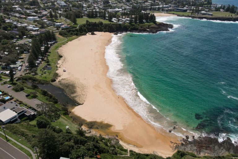 An aerial shot of a beach called Kendalls Beach and a beachfront accommodation called Kendalls on the Beach in Kiama