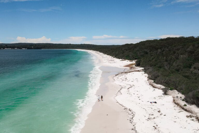 Couple walking along Hyams Beach, one of the best beaches in Jervis Bay