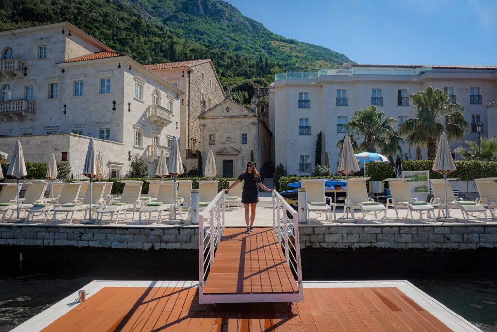 Woman walks down onto the Heritage Grand Perast hotel jetty in Montenegro
