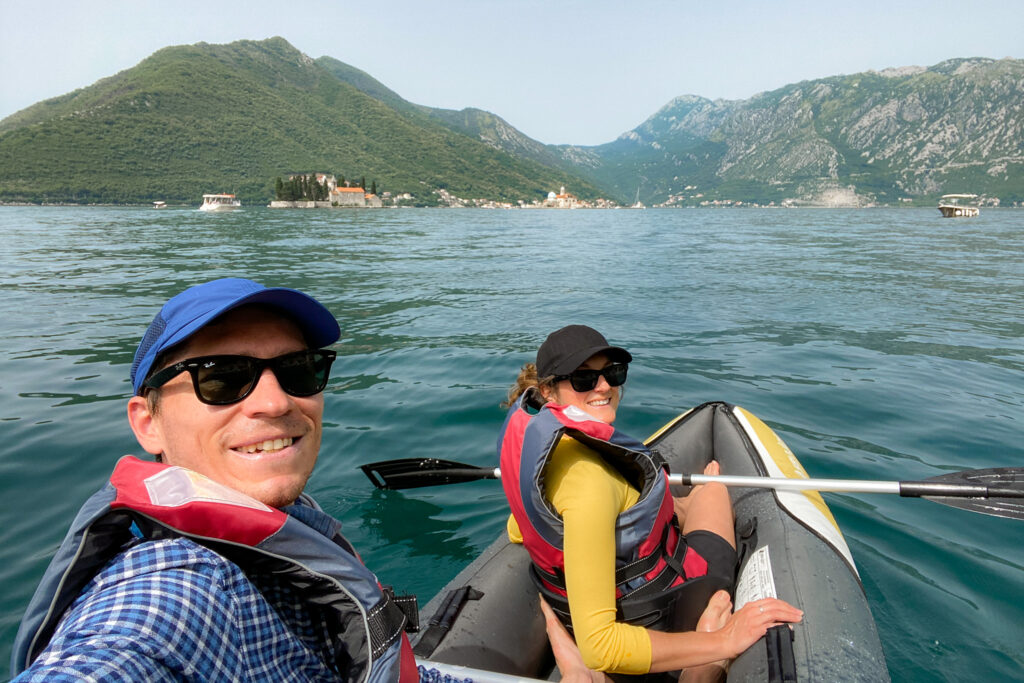 Couple enjoy kayaking on the Bay of Kotor surrounded by mountains