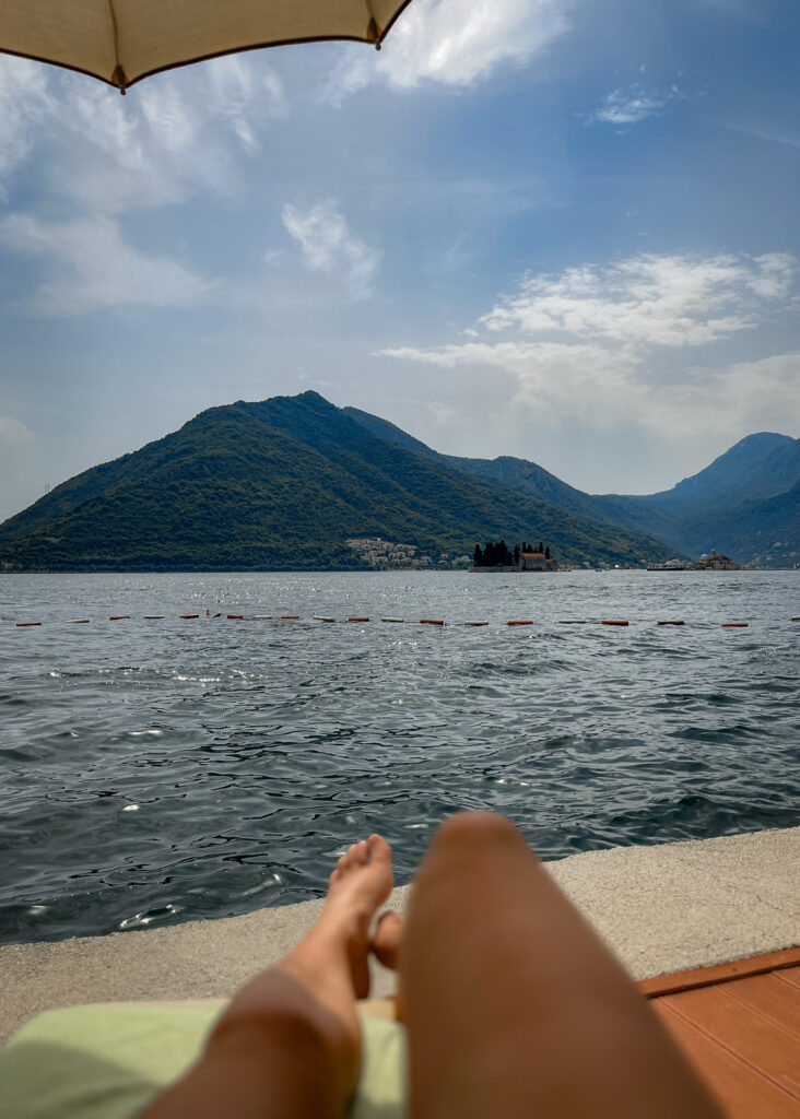 Sunbathing on the shores of Perast Montenegro with views of Our Lady of the Rocks islet