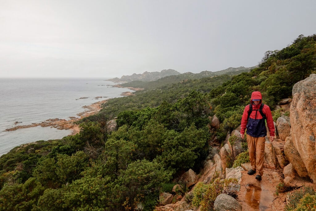 Dan walks on a rainy day on a wet trail during the Capo di Fenu Walk in Bonifacio