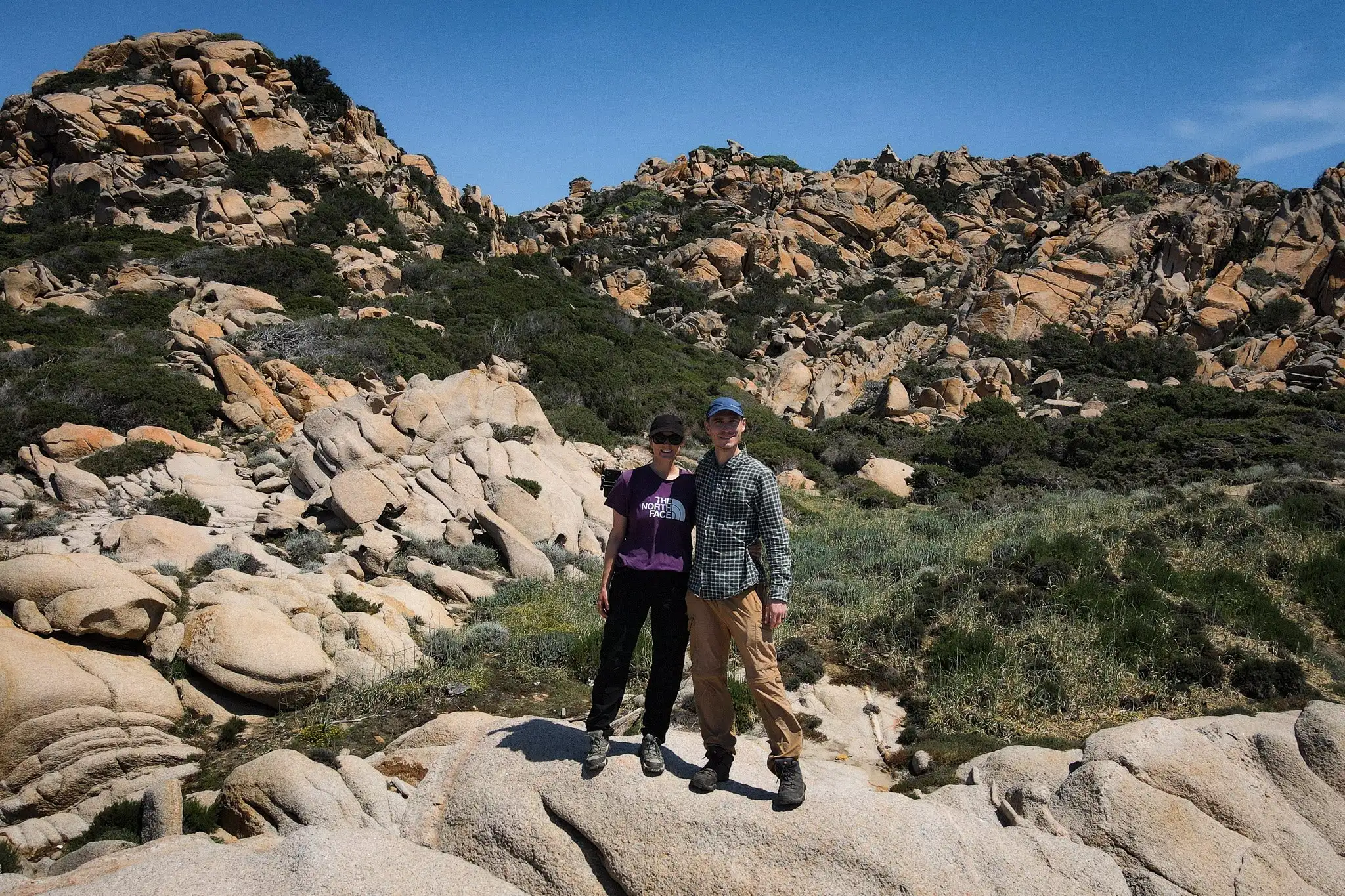 Dan and Beck stand together on a rocky coastline during the Capu di Muru Walk