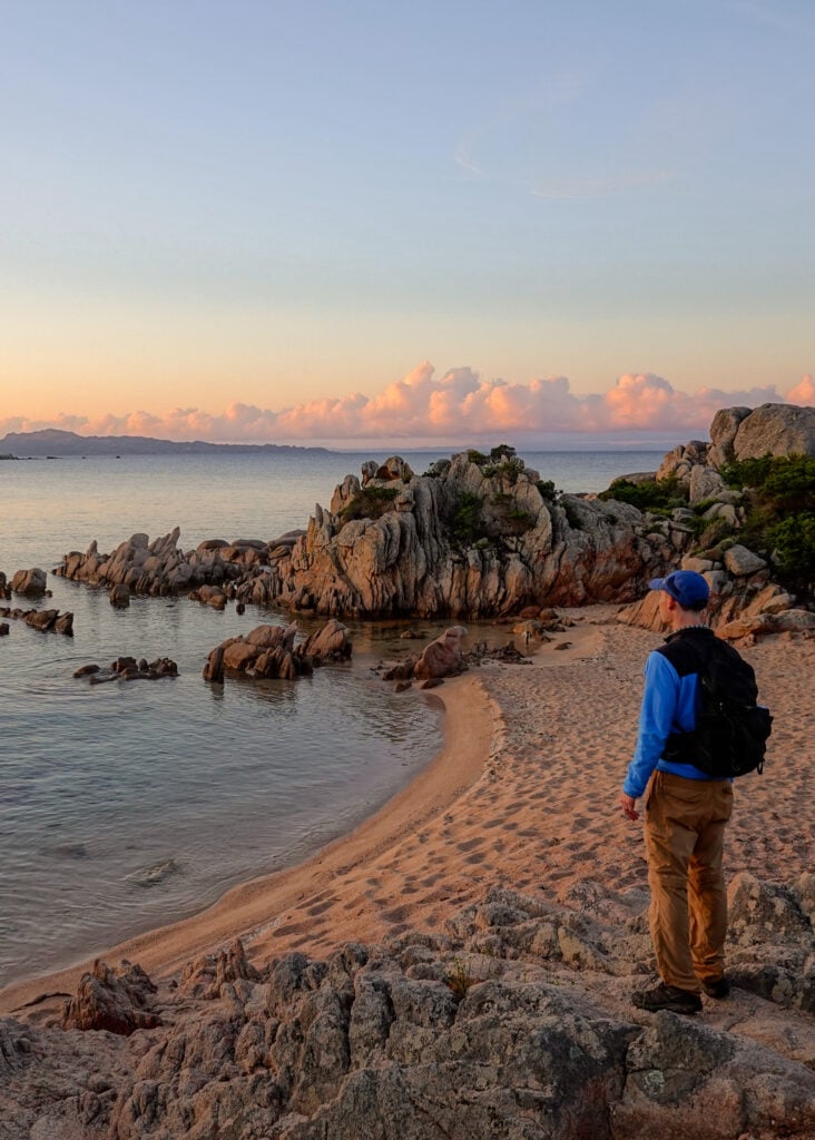 Dan watches the sunrise on a beach on Sentier Littoral des Bruzzi in Corsica