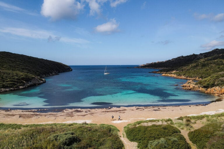 Dan and Beck walk on a beach during a walk in Corsica called Strada Vecia Madonetta