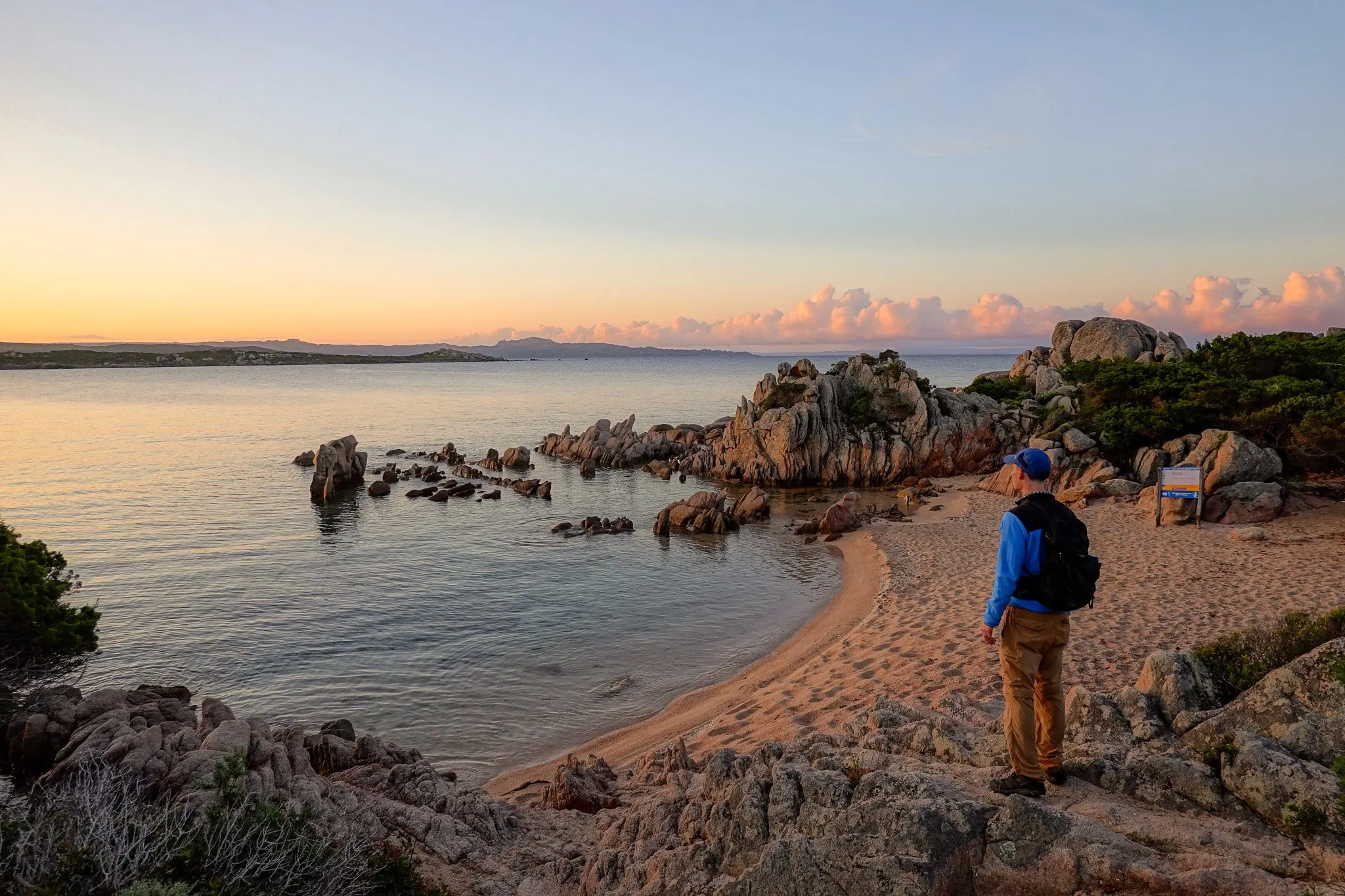 Dan stands on a beach at sunrise during a walk called Sentier Littoral des Bruzzi in Corsica