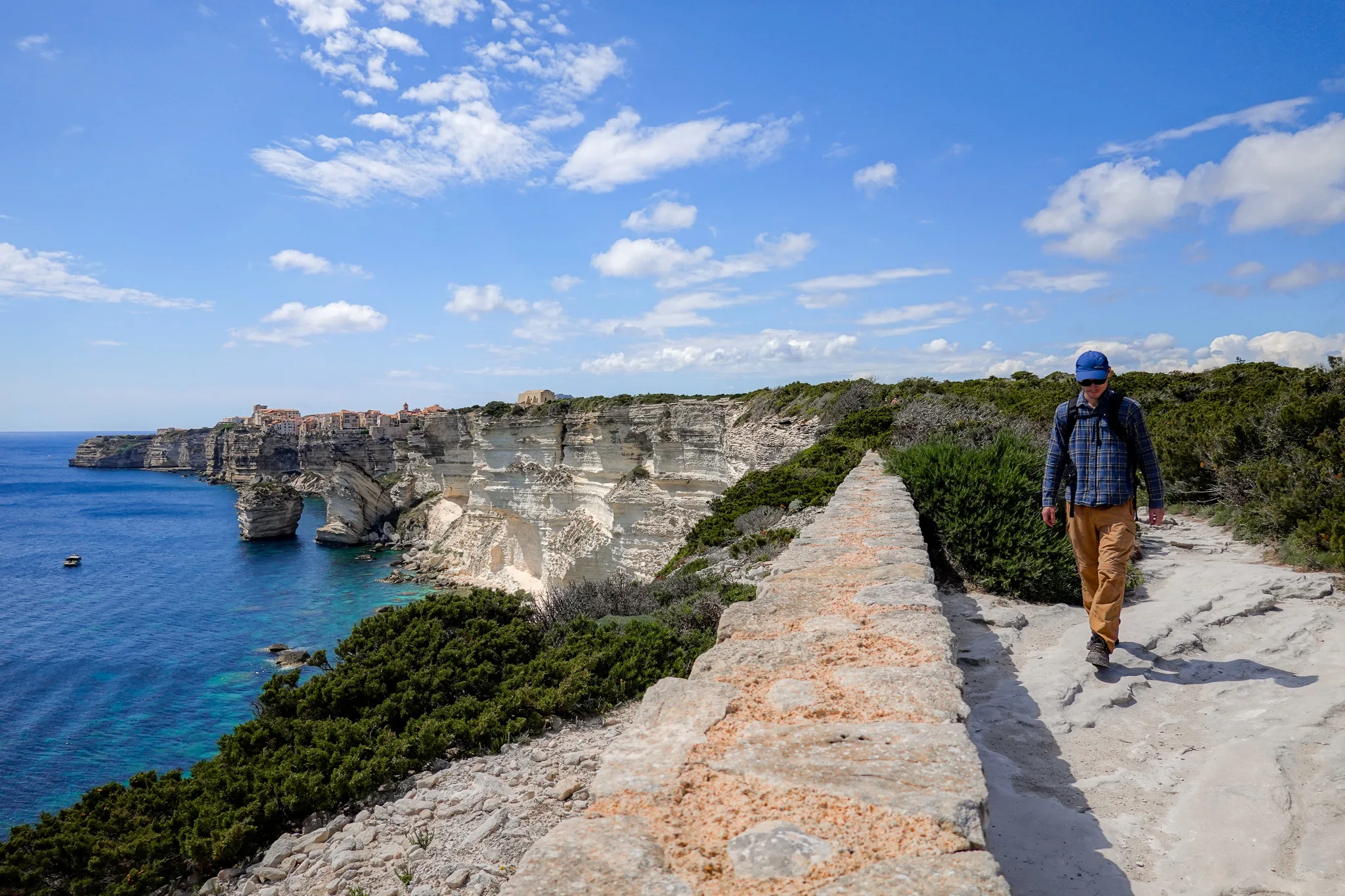 Dan is walking by white seaside cliffs while doing Campu Rumanilu, which is also known as the Bonifacio Cliff Walk