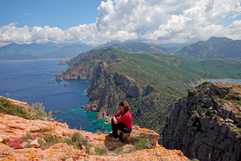 Beck looking at the coastal views from the peak of the Capo Rosso Hiking Trail