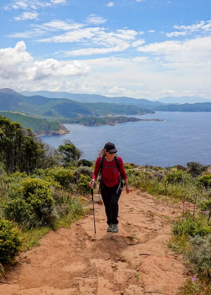 Beck walks up the Capo Rosso Hiking Trail surrounded by the coast