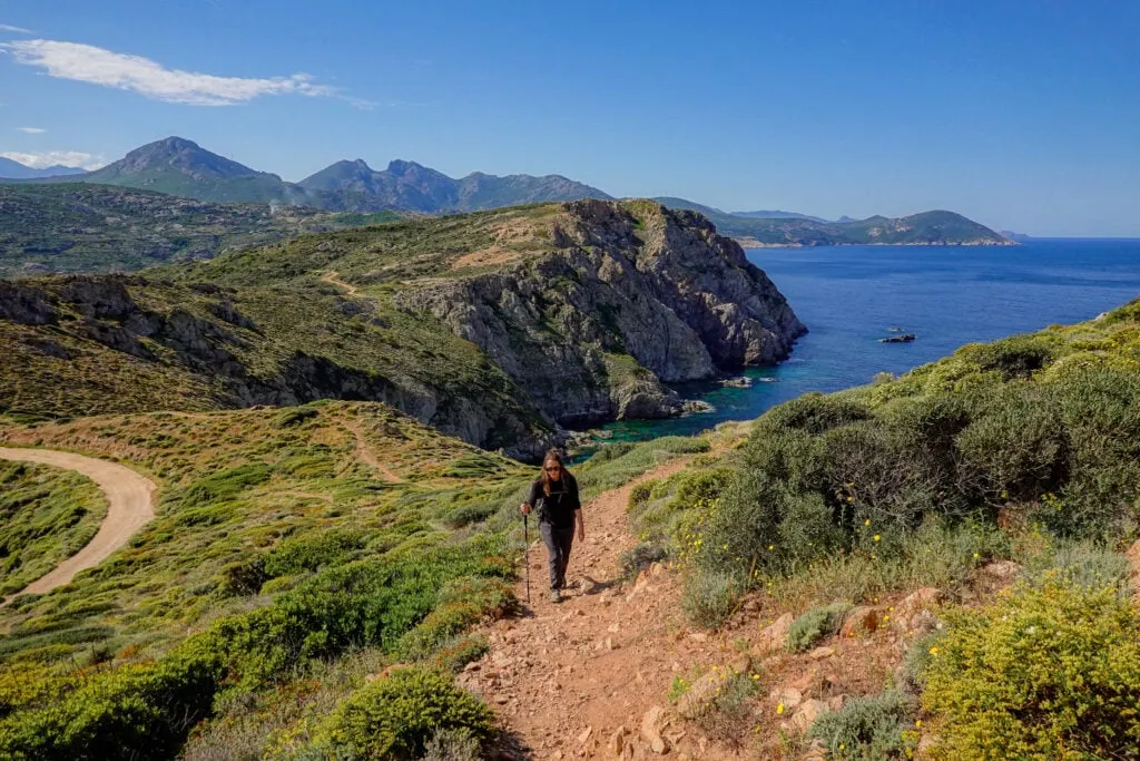 Beck walks up a trail on a peninsuloa in Corsica called Pointe de la Revellata