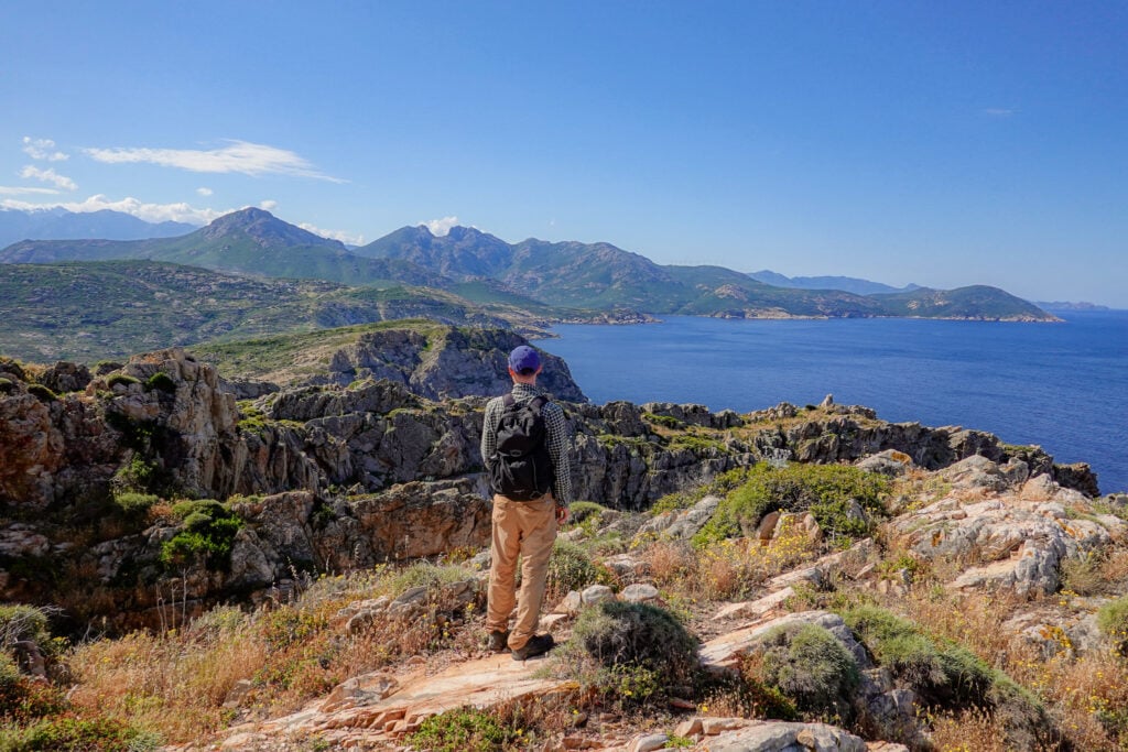 Dan looks towards the sea on a clear day on Pointe de la Revellata in Corsica
