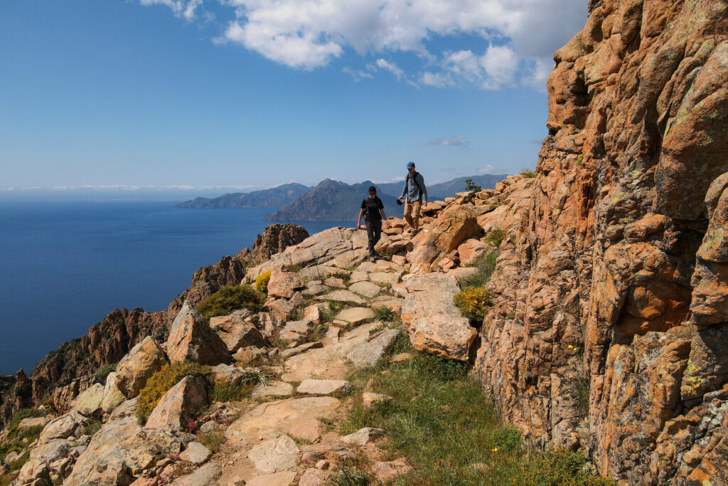 Dan and Beck walking down a coastal trail called Sentier Muletier during the Calanques de Piana Hike