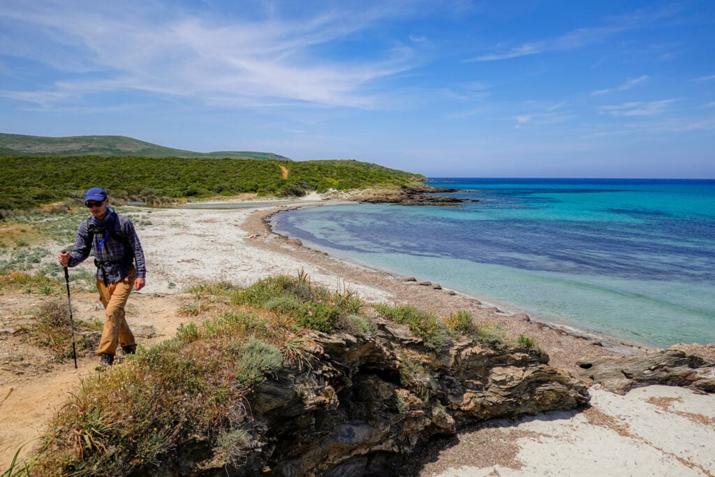 Dan walksa way from a beach on a sandy track on a coastal walk called Sentier des Douaniers Cap Corse