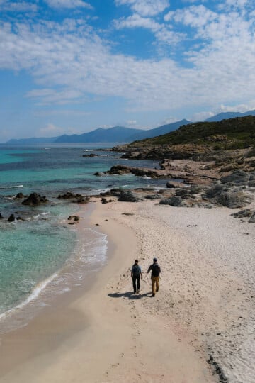 Dan and Beck walk on Saleccia Beach during a coastal walk called Sentier des Douaniers Saint-Florent