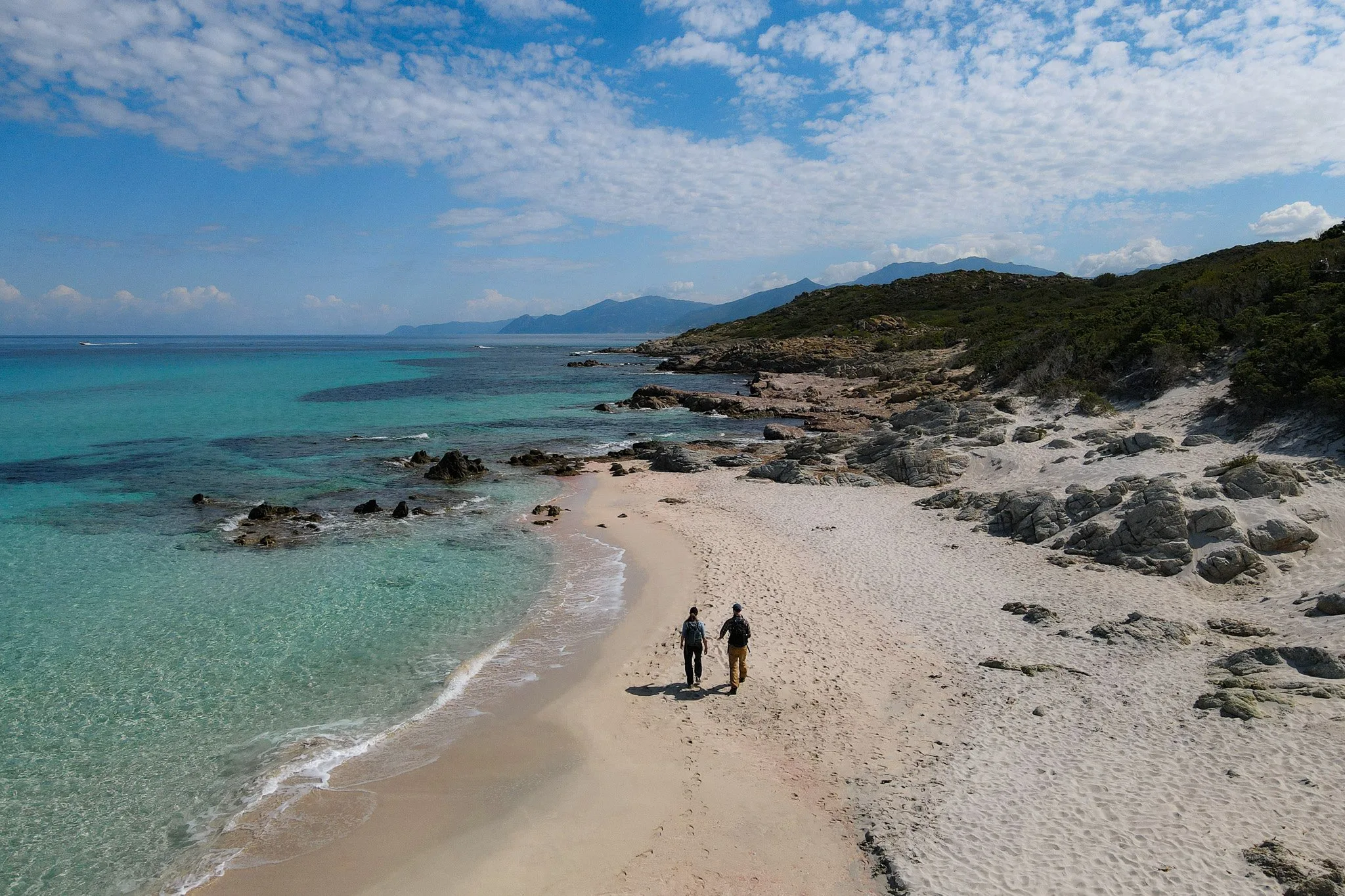 Dan and Beck walk on Saleccia Beach during a coastal walk called Sentier des Douaniers Saint-Florent