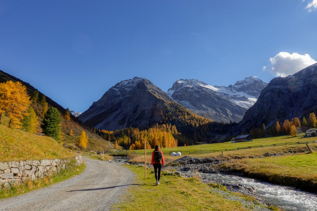 Beck walks along a river stream in a mountainous area