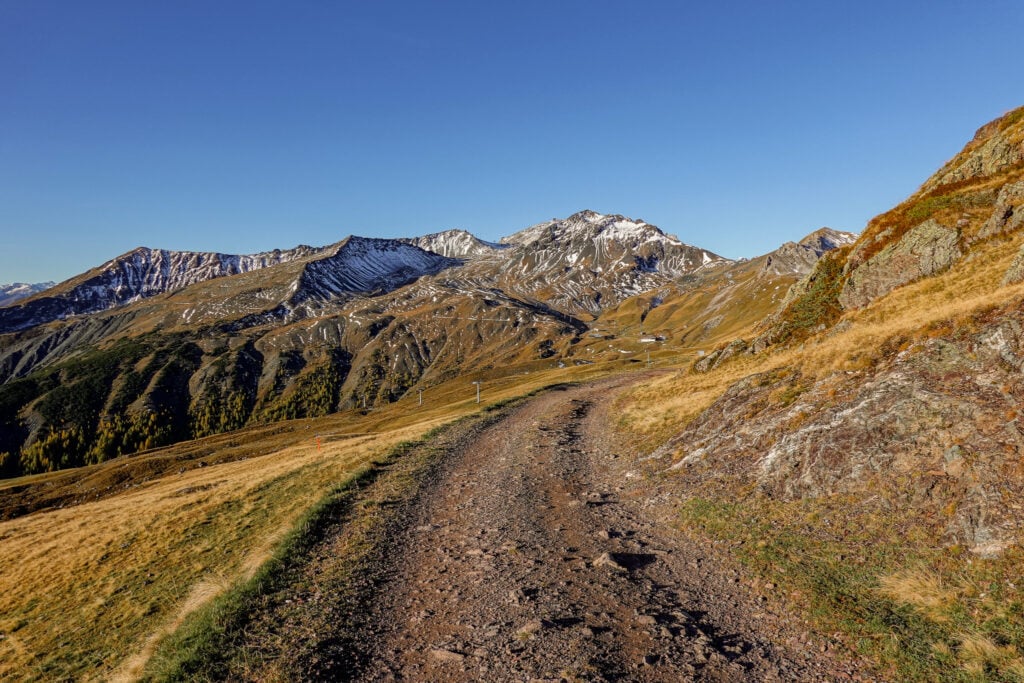 The Davos Panoramaweg winds towards some snowy mountains