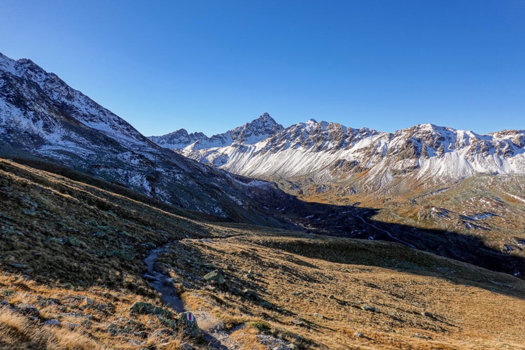 A trail (Joriseen Hike) winds towards snowy mountains