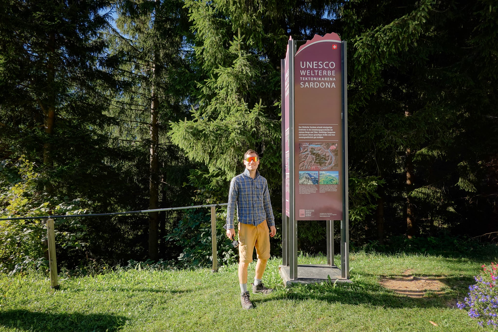 Dan stands by an information sign next to the trailhead for the Berglistüber Waterfall Hike