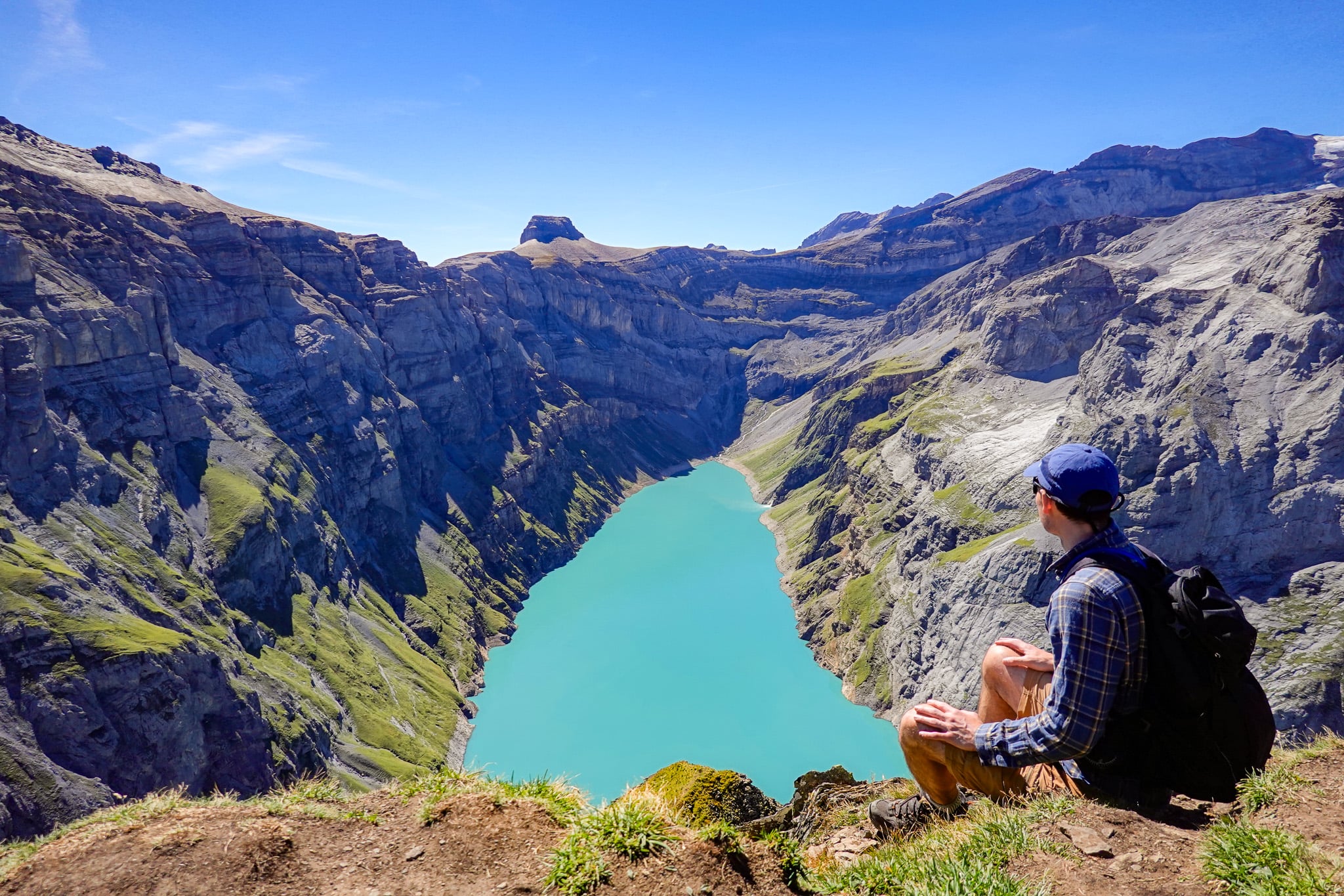 Dan is sitting and looking at a lake called Limmernsee from a peak called Muttenchopf during the Limmernsee Hike