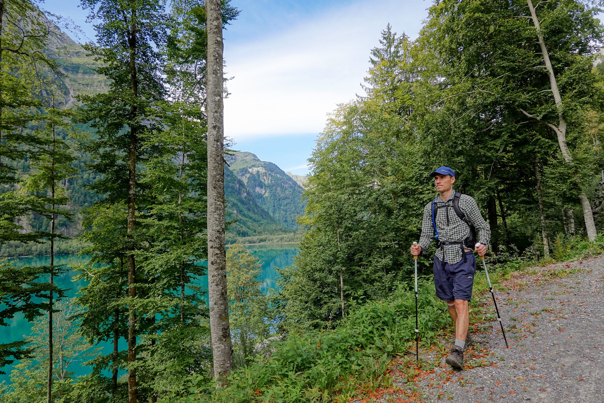 Dan walks on a trail near a lake surrounded by forest during a walk called Klöntalersee Rundweg