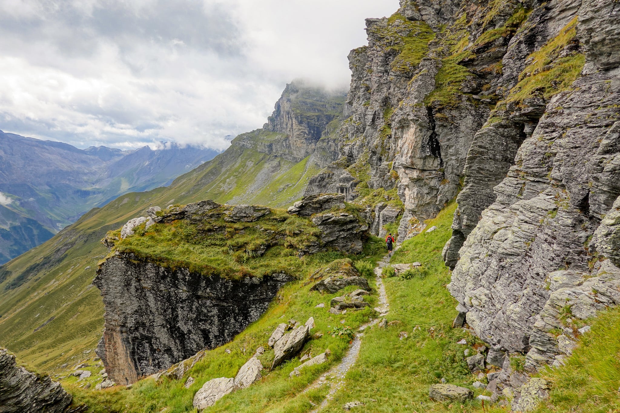Dan walks in a mountainous landscape during a hike called Kärpfwanderung, which is one of the best Glarus hikes.