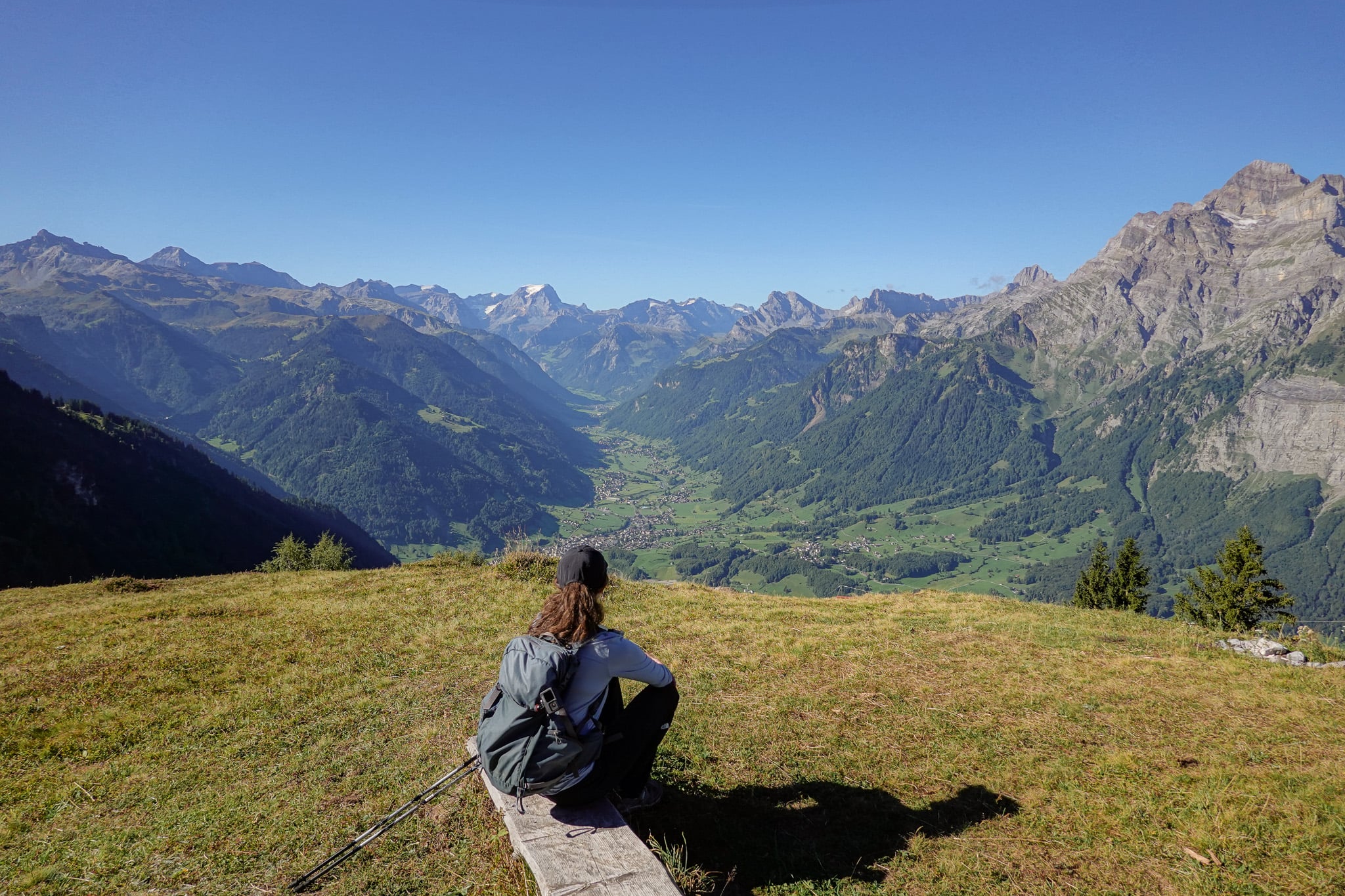 Beck has a seat on a wooden bench looking at a valley during a walk called Holzflue Rundweg