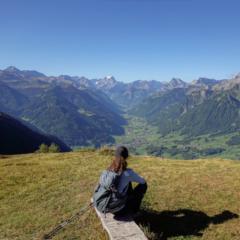 Beck sits and looks at views of mountains during a walk called Holzflue Rundweg