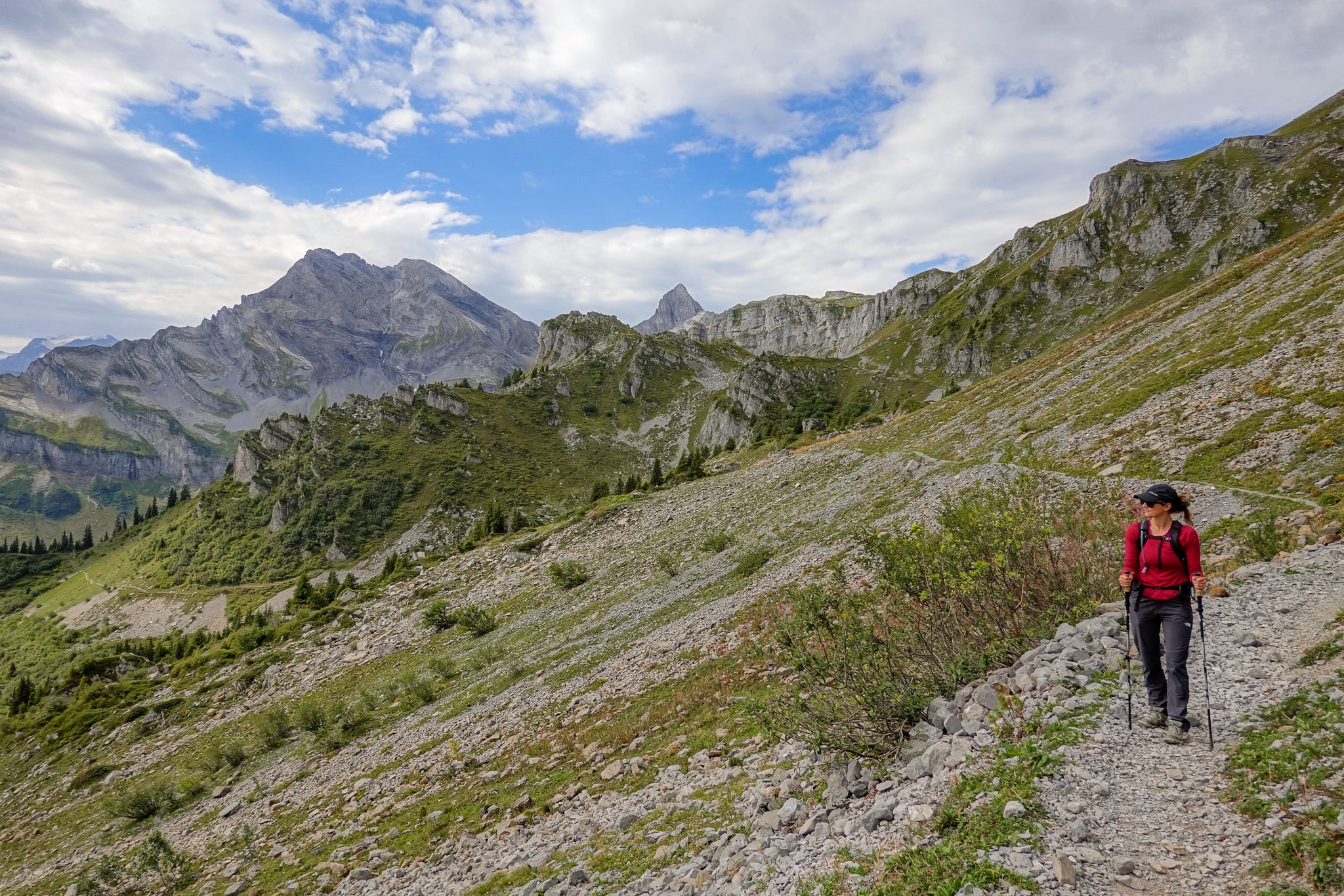 Beck walks on a rocky trail with mountains seen in the distance on a circular route called the Braunwald Panoramaweg