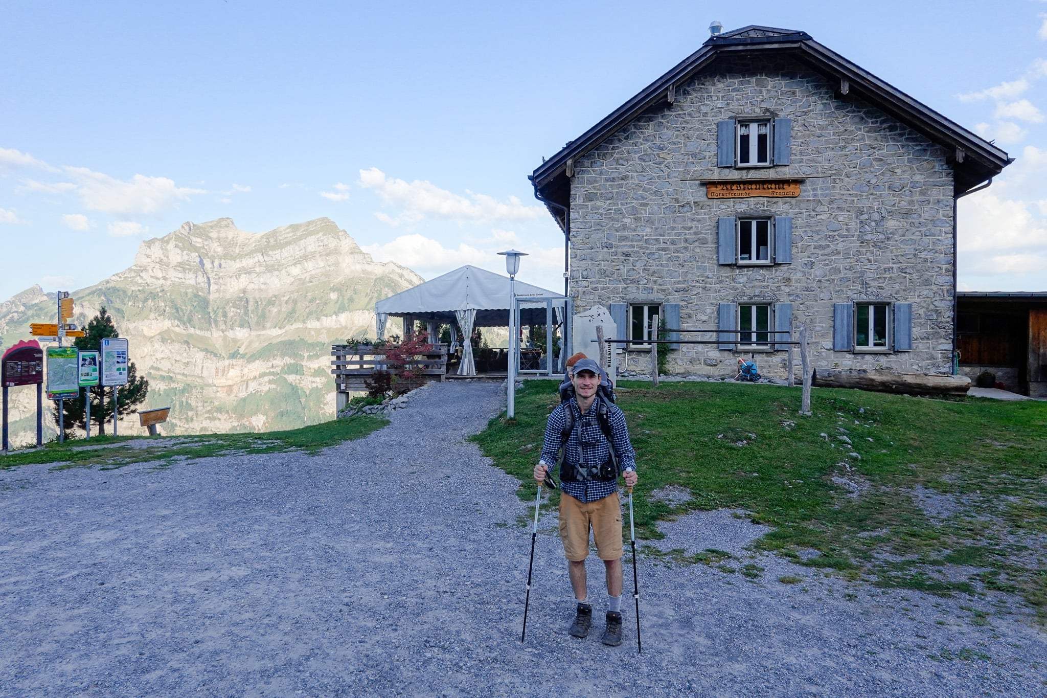 Dan with a child carrier backpack near a mountain hut at one of the end of the Schabziger Höhenweg
