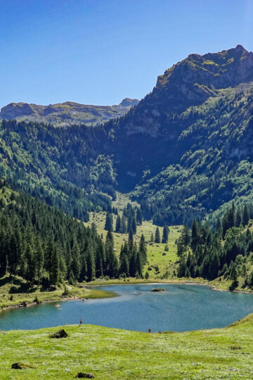 A lake called Talalpsee is surrounded by mountains during a circular walk called the Habergschwänd Talalpsee Hike